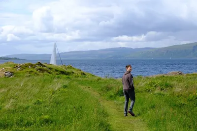 Eli Bosley walking near a coastal hillside